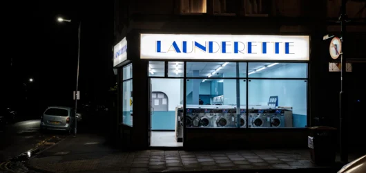 Et opplyst lokalt vaskeri om kvelden, som symbol på at en enkel nettside kan være live samme kveld